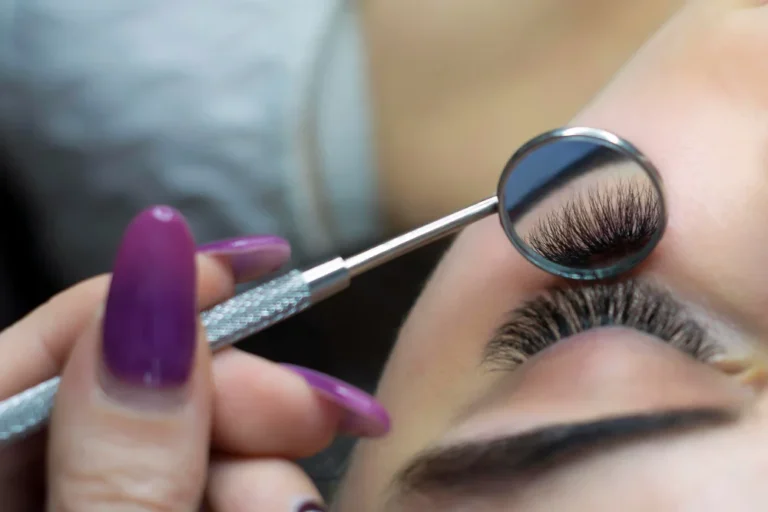 Blog Bild zum Beitrag wie lange hält Wimpernverlängerung. Eine Wimpernverlängerung wird mit einem Zahnarztspiegel von unten gezeigt.